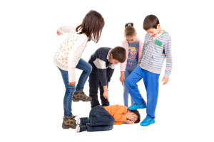 Group of children bullying an isolated child
